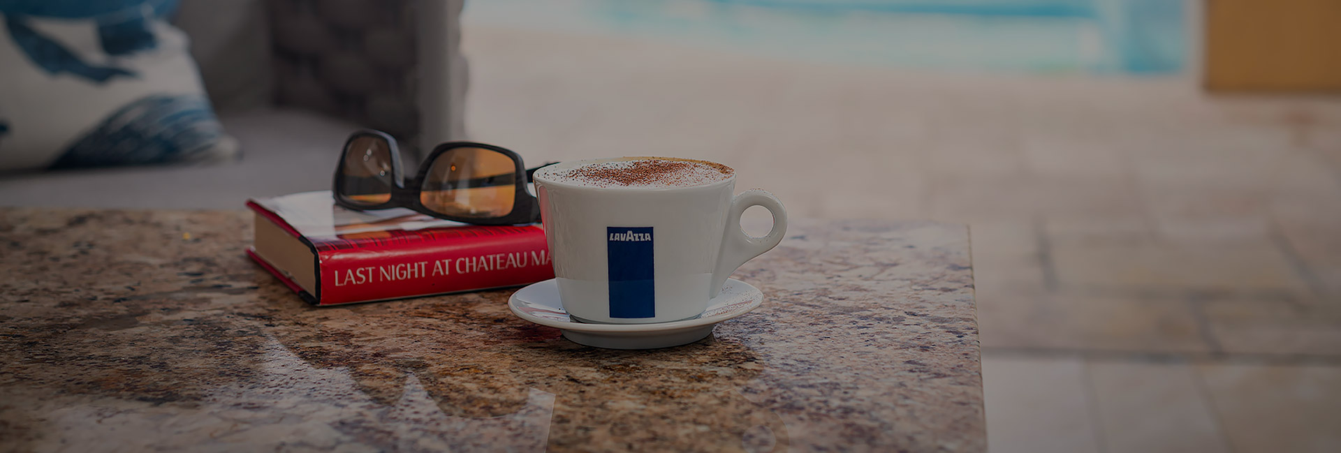 cup of coffee, book, and sunglasses on a table