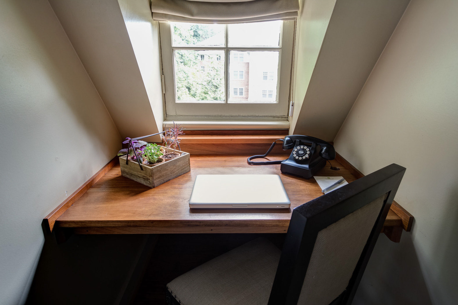 small desk in nook with phone and note pad 