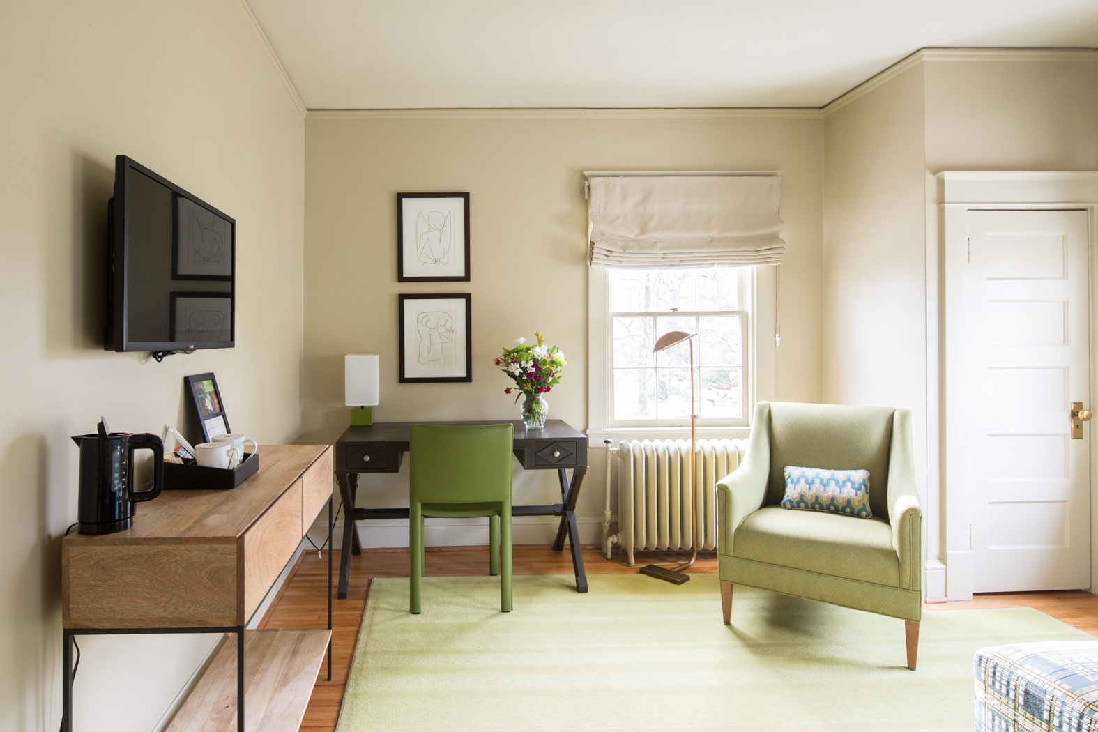 queen suite with desk, green accent color and a tv 