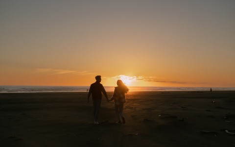 Two people walking into the sunset