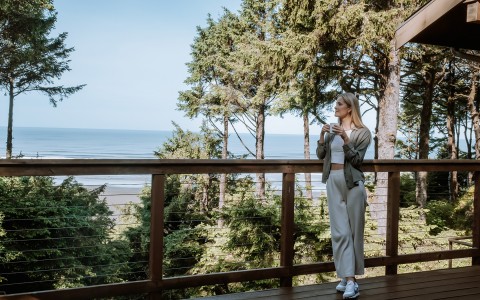 Woman standing on deck looking at the ocean