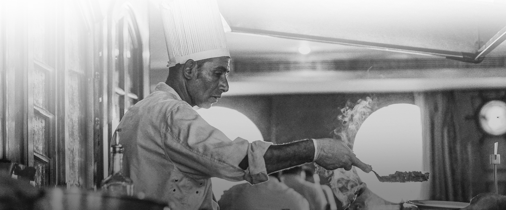 Black and white image of a chef grilling burgers