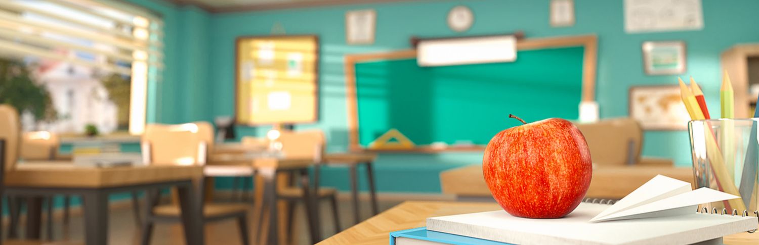 red apple on books in classroom