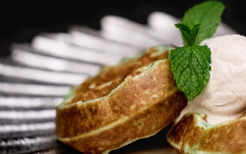 Potato cakes with dallop of cream and mint leaf 