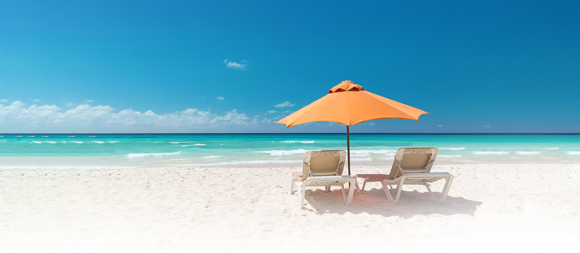 lounge chairs and orange umbrella on the beach