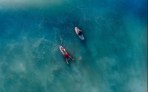 img-aerial view couple surfing