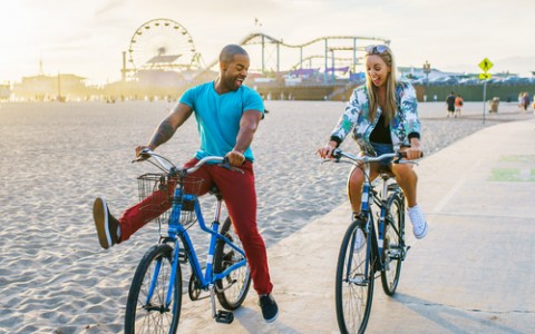 Couple bike riding by Pier 