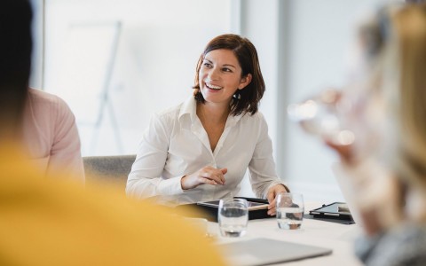 lady smiling while she's attending a meeting 