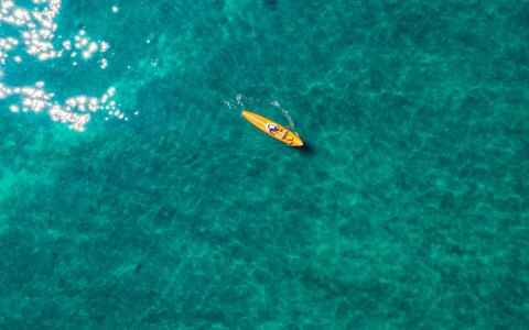above picture of a yellow kayak in the ocean
