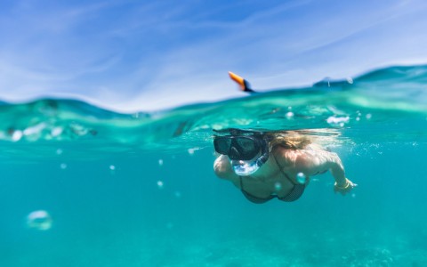girl snorkeling in the clear blue water