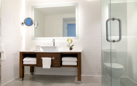 bathroom in the hotel room with a white sink and wooden base