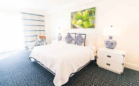 hotel room with white comforter set and diamond pattern carpet