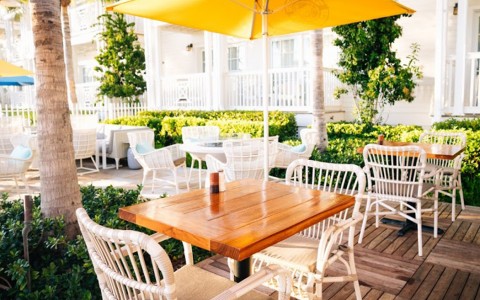 outside seating featuring a yellow umbrella and wooden table 