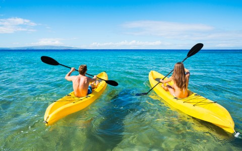 couples kayaking in clear blue water