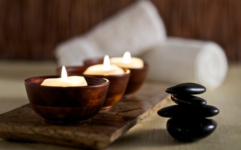 candles with black stones and white towels 
