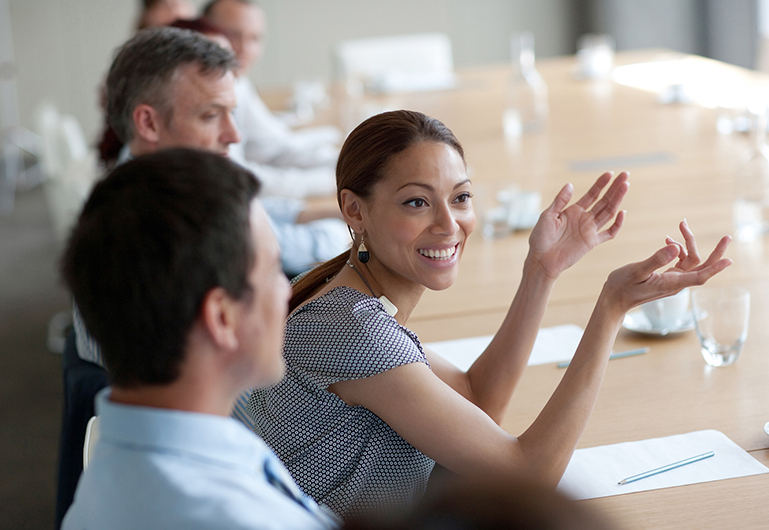 People in a meeting where a woman is explaining and the guys are listening