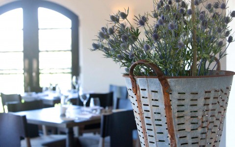 basket with purple flowers in the table of a restaurant 
