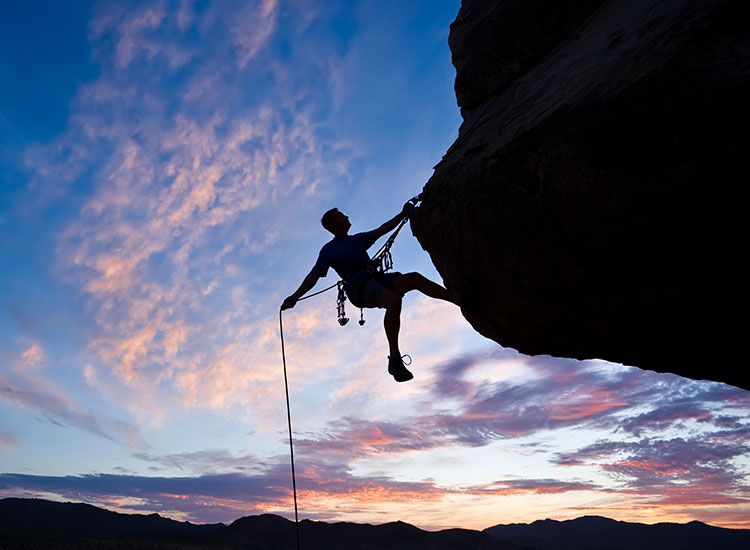 Man rock climbing close to sunset