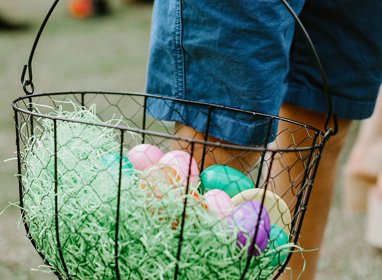 wire basket of plastic eggs and paper grass