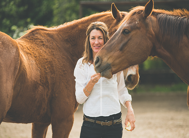 Woman standing with a couple of horses