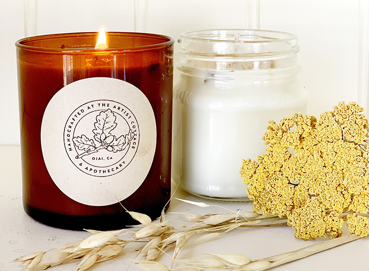 lit candle with flowers next to it