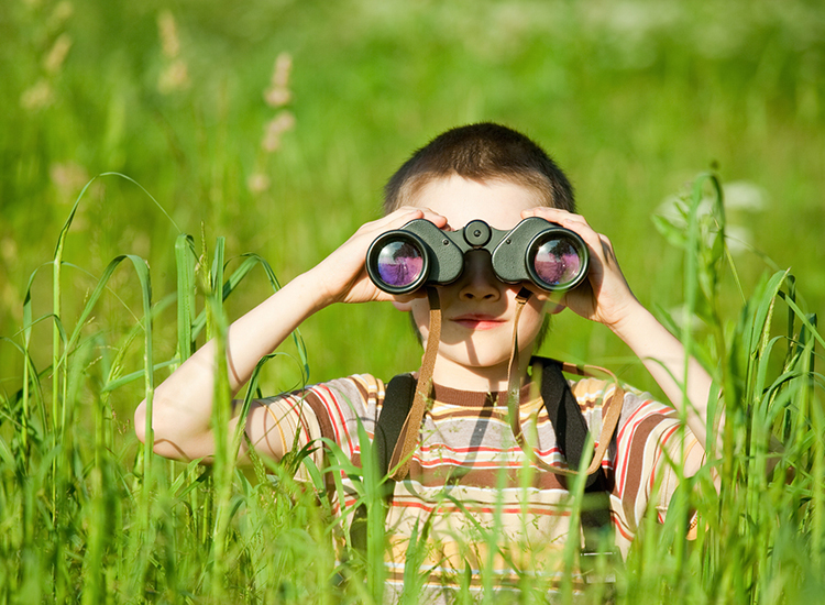 Little kid looking through binoculars  