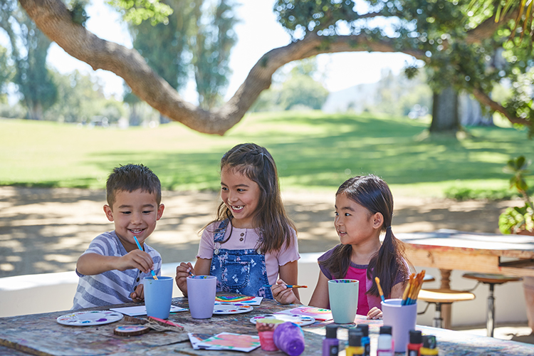 3 children painting together in the park