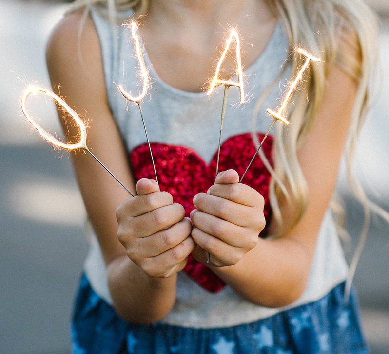 little girl holding sparklers that spell at ojai