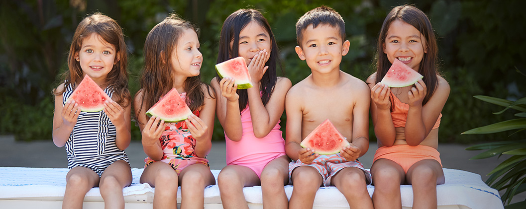 Three kids having watermelon slices