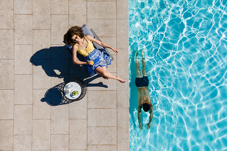 Woman sunbathing while a man swims next to her