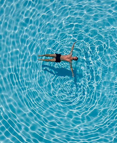 Man floating in the middle of a pool