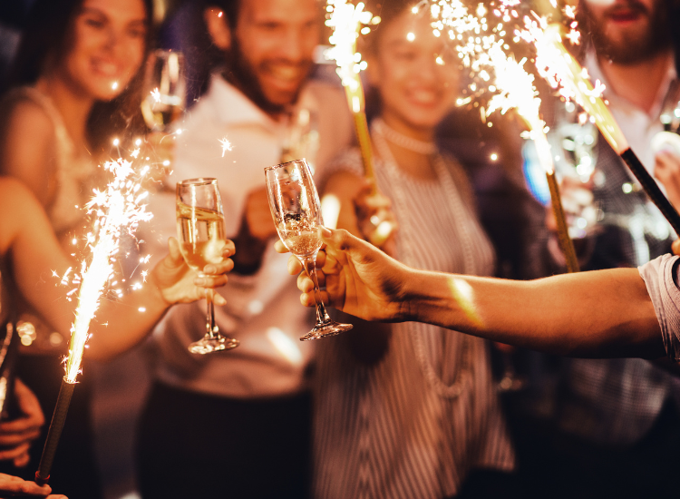 group of people holding sparklers and celebrating with champagne