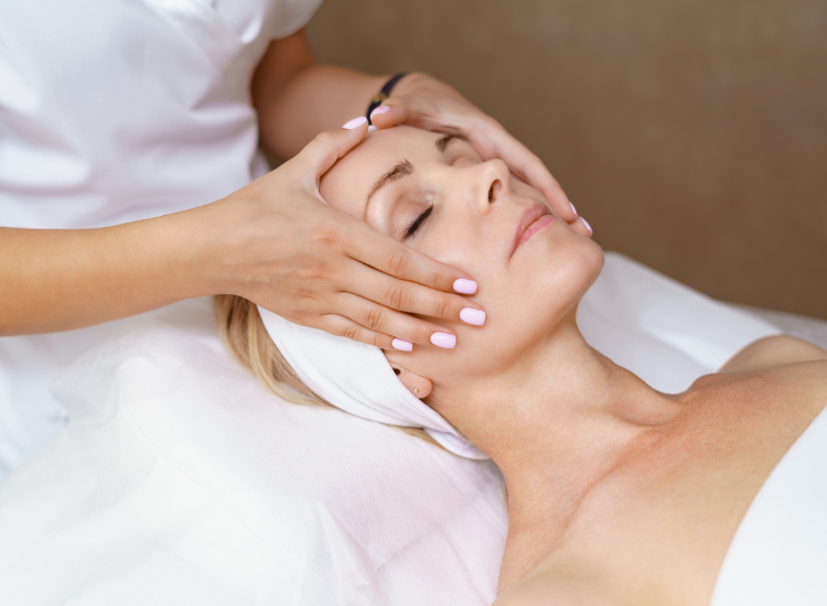 Woman laying down while doing a facial massage 