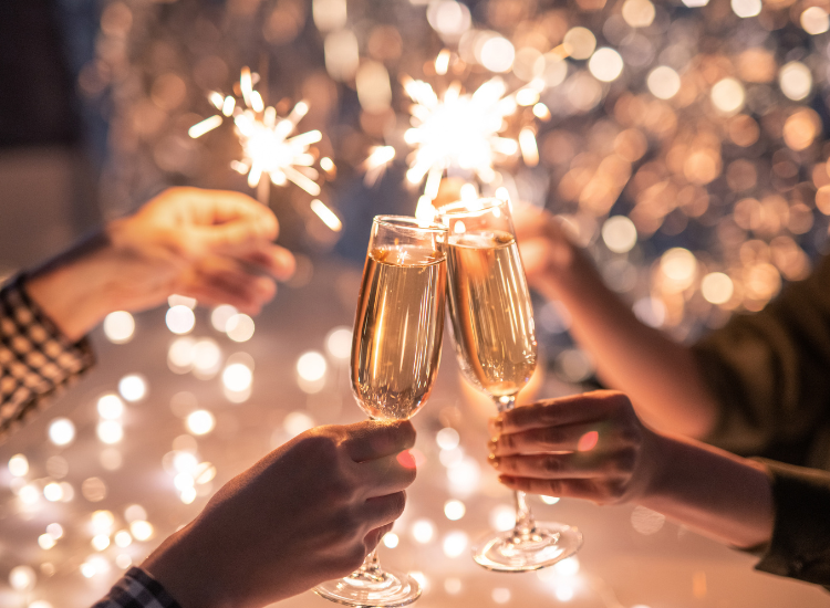 People holding sparklers and cheering with champagne glasses 