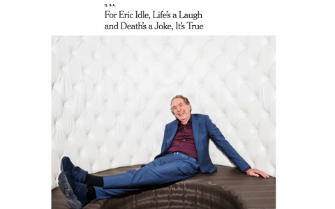 Eric Idle sitting on brown leather couch