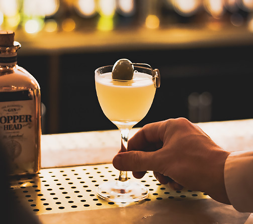 Hand reaching for drink on bar