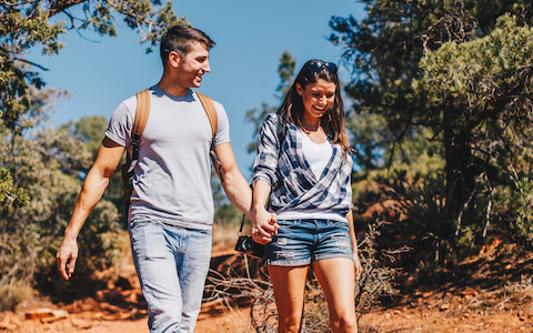 couple holding hands and hiking through adobe jack trail