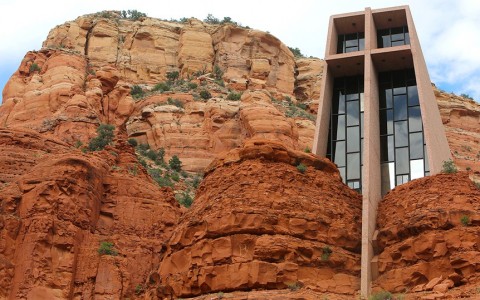 a church built into the side of a red rock mountain