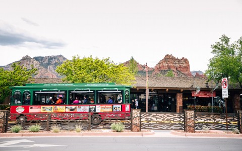 a trolley bus with red rock mountains in the distance
