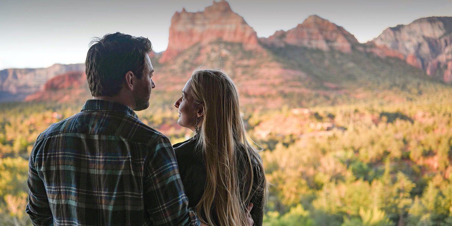 couple on balcony looking at red rock mountains view