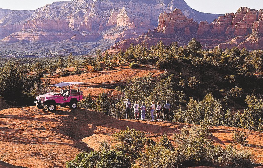view of a pink group and tourist group on a dirt road 
