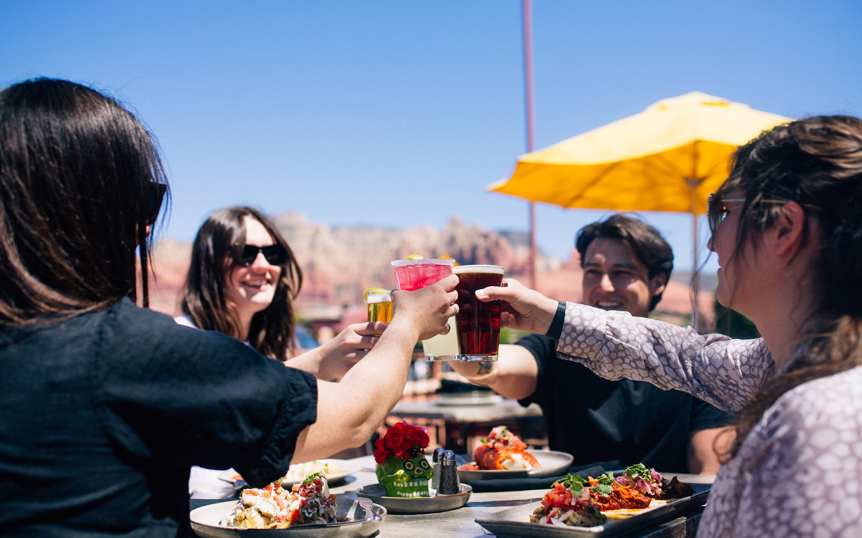 A group of friends enjoying a colorful lunch with colorful drinks on a sunny day at 89agave cantina
