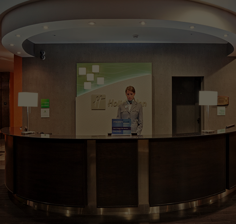 Woman standing behind the front desk at a Holiday Inn hotel