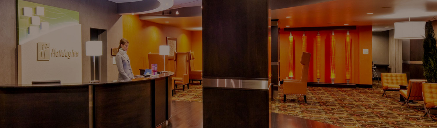 Interior of Holiday Inn lobby with woman at front desk
