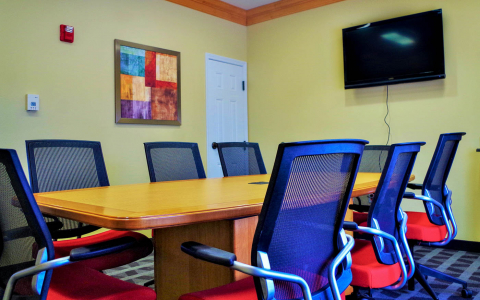 Conference room with a table and eight chairs and a flat screen television
