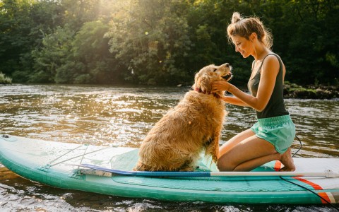 lady with her adorable dog doing water sports  in a lake 