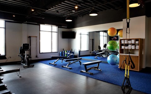 gym with blue mats and medicine balls