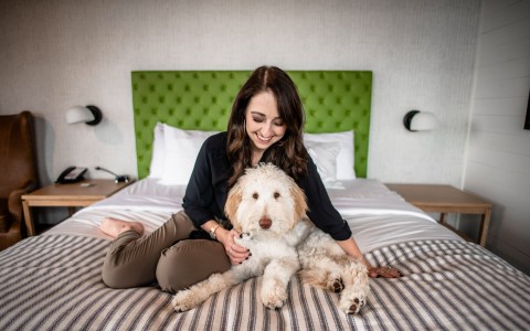 woman and dog sitting on bed