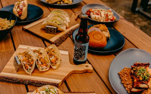 table with plates with tacos and beer
