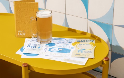 blue lacy menu and drink menu with beer on yellow table